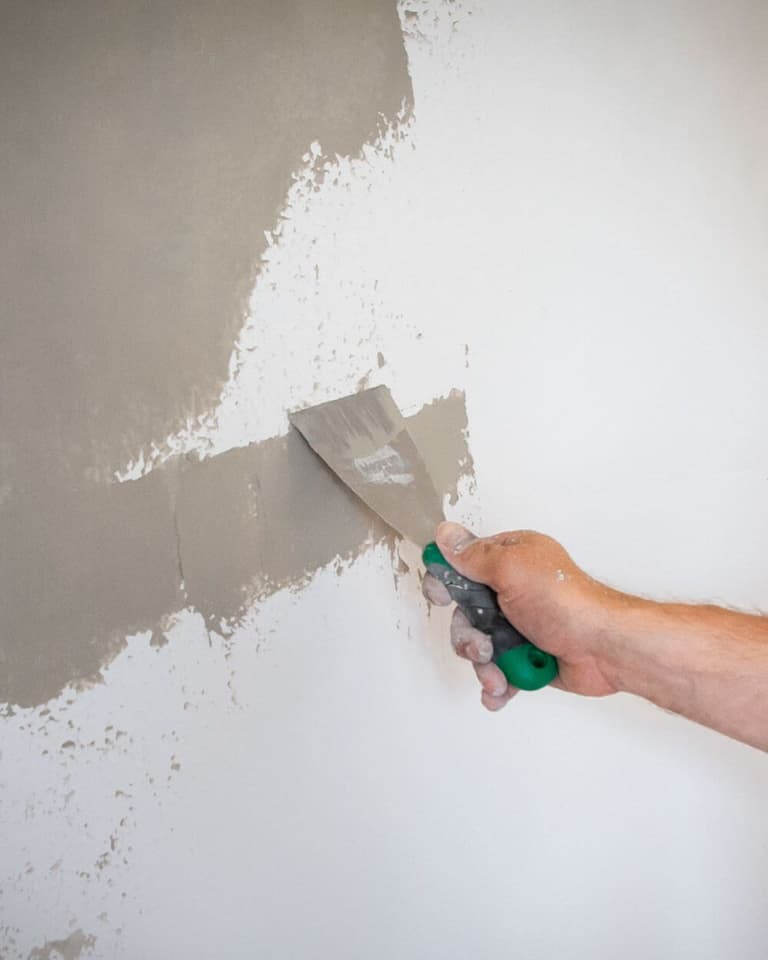 Nakładanie szarej gładzi Megaron szpachelką.